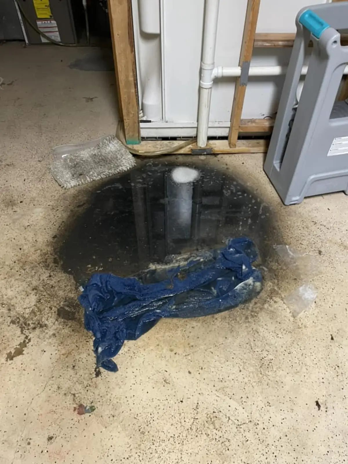Standing water on a basement floor before a Drain Dudes service call.